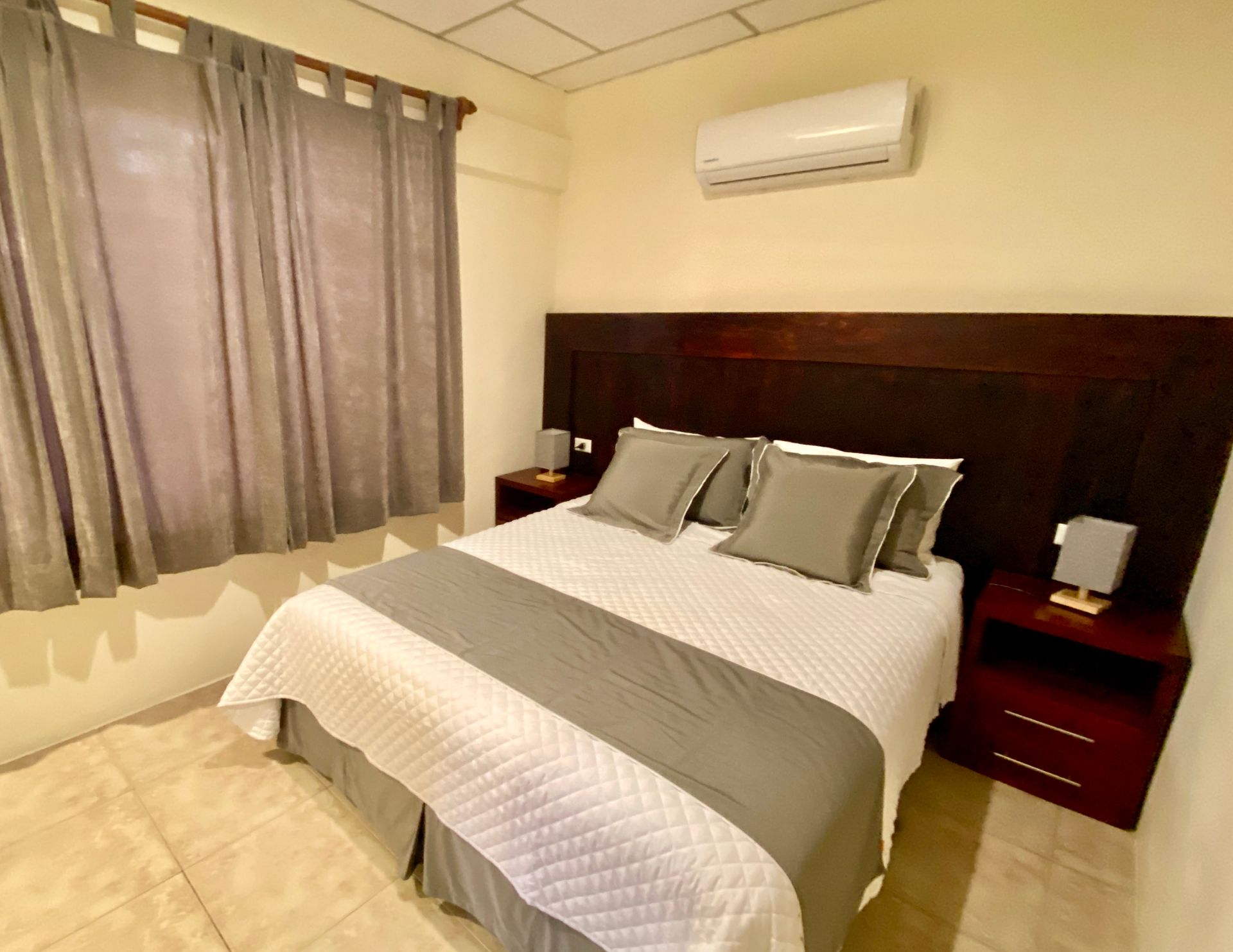 A hotel room with a king size bed and a window