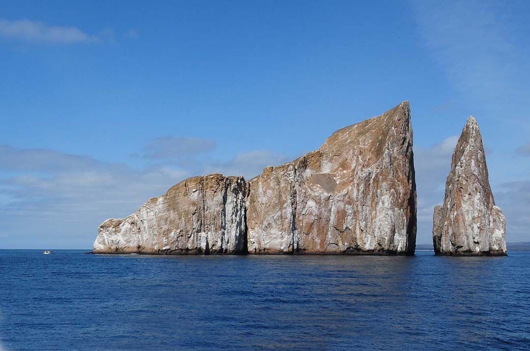A large rock formation in the middle of the ocean.