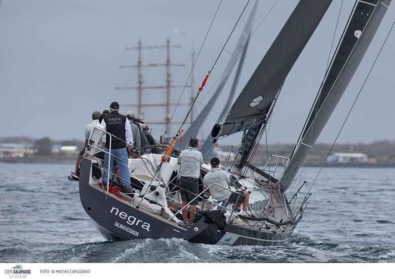A group of people are on a sailboat in the ocean.