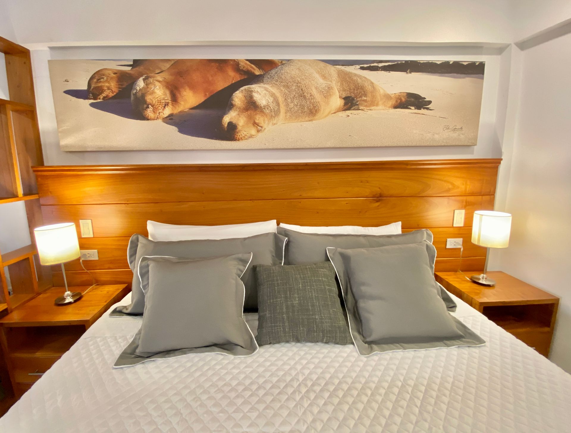 Bedroom with a large wooden headboard and bedside tables.