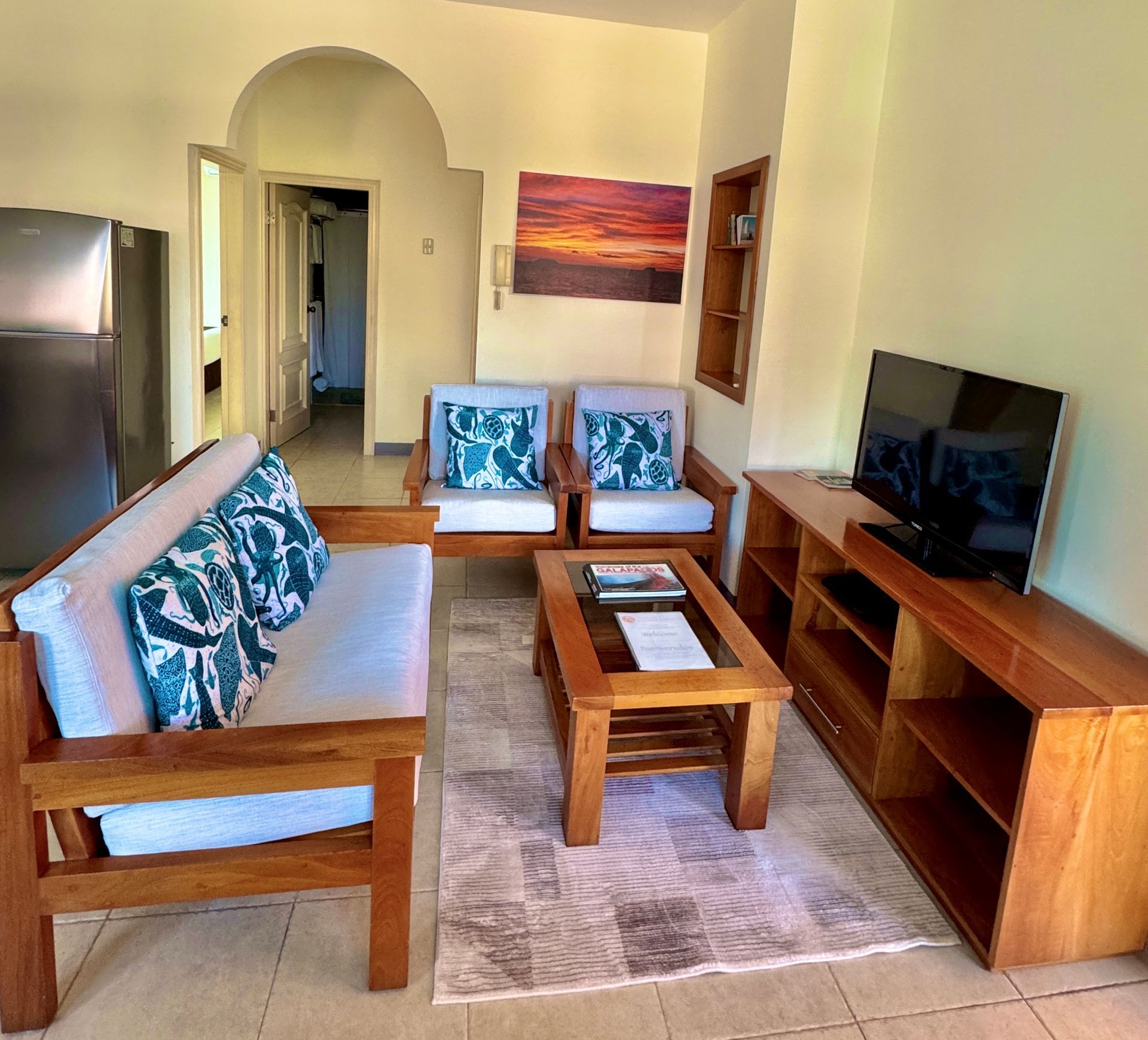 Living room with wooden furniture, including a sofa, loveseat, coffee table, and TV stand.