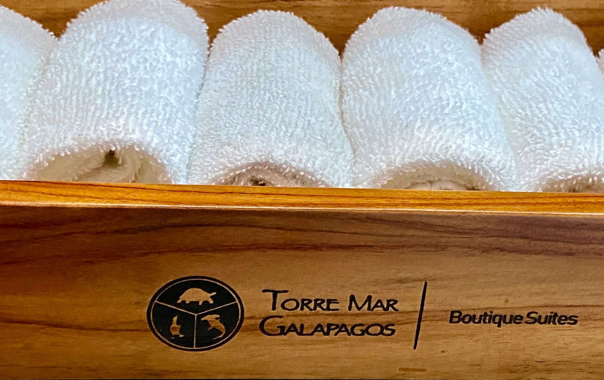 A wooden box filled with white towels from torre mar galapagos
