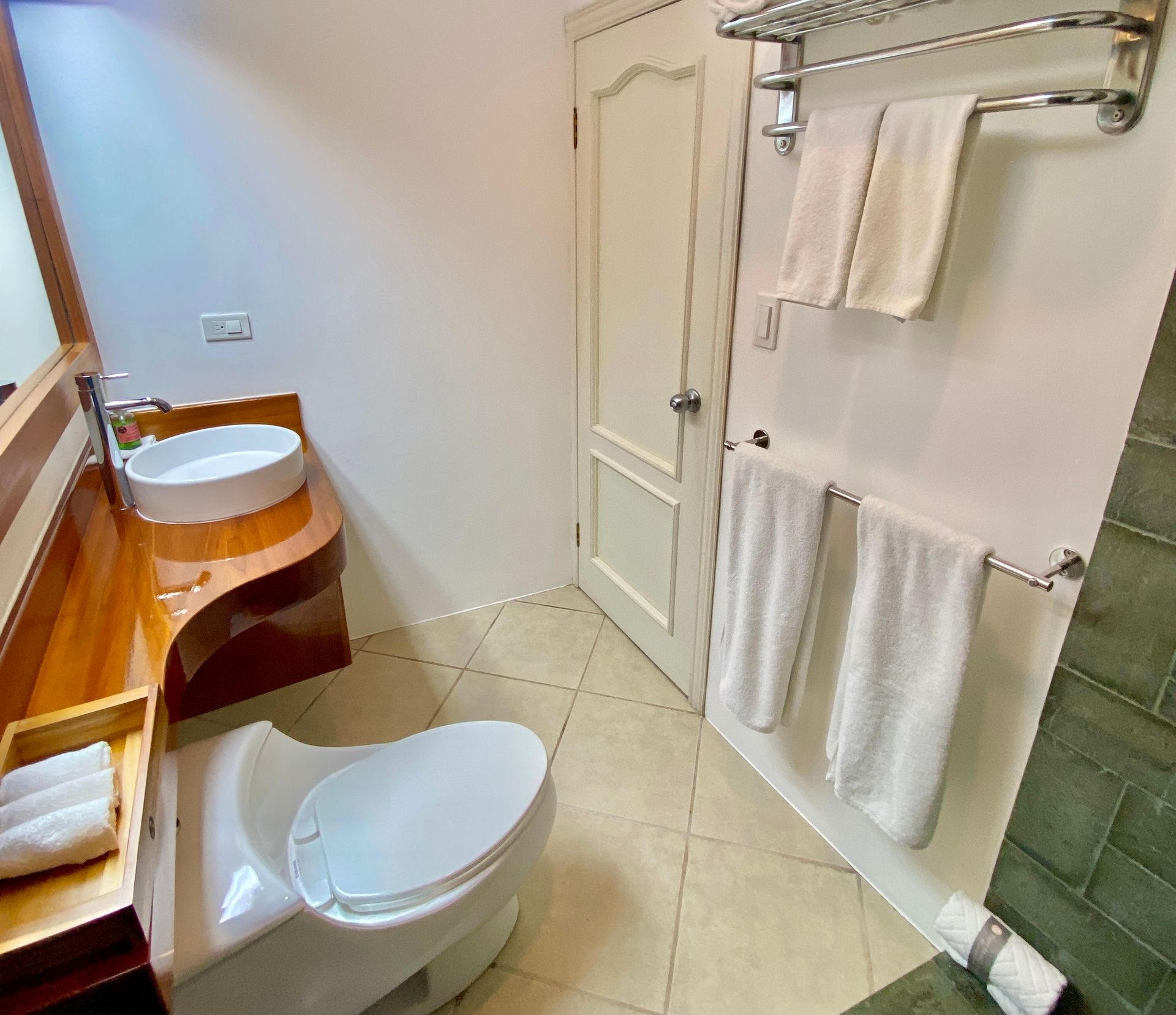 A bathroom with a toilet , sink and towel rack