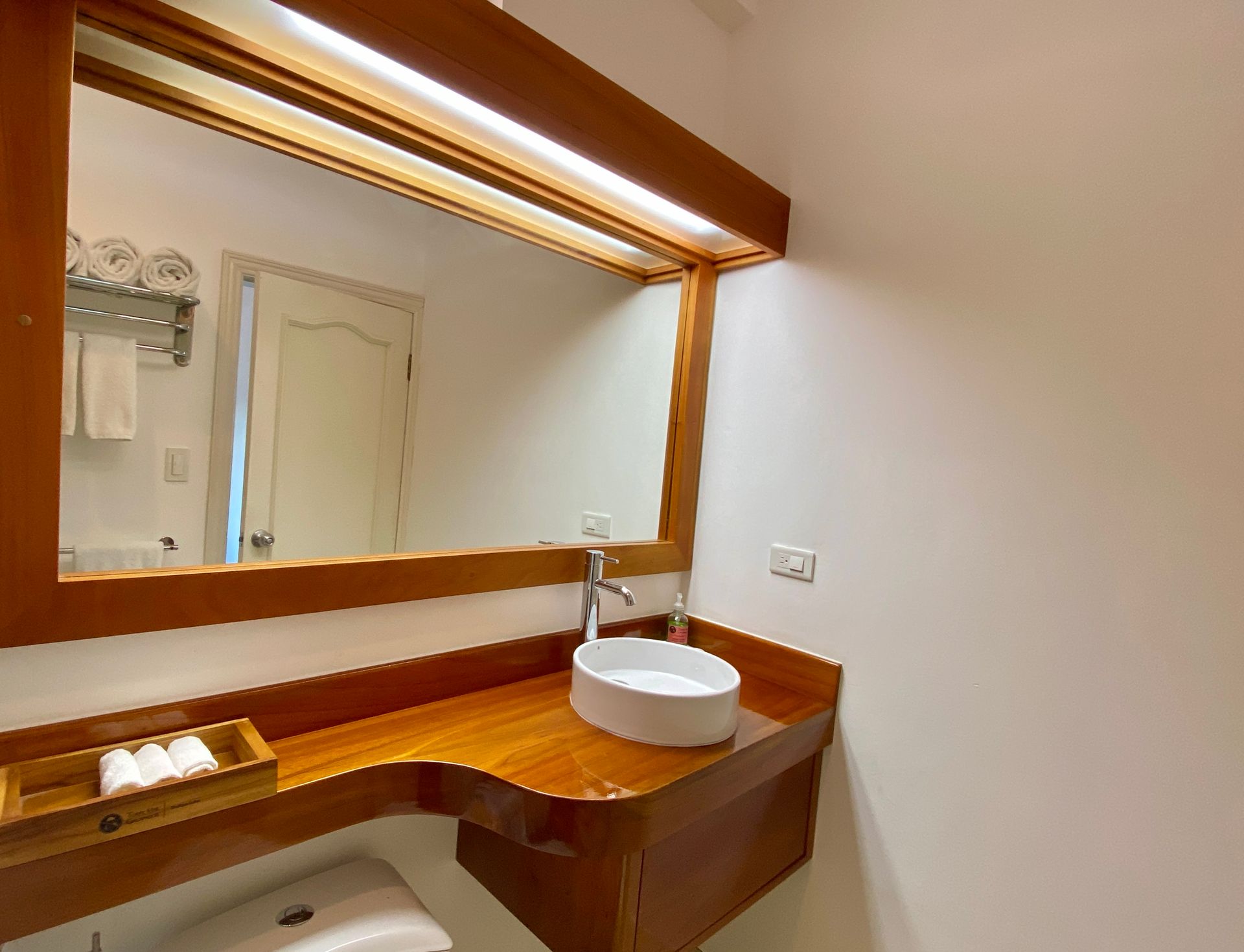 A bathroom with a sink , mirror and toilet.