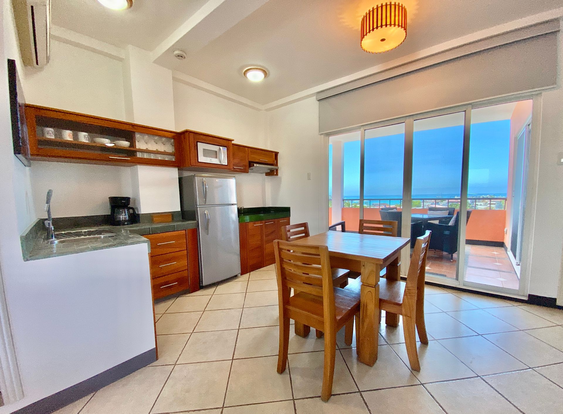 A kitchen with a table and chairs and a view of the ocean.