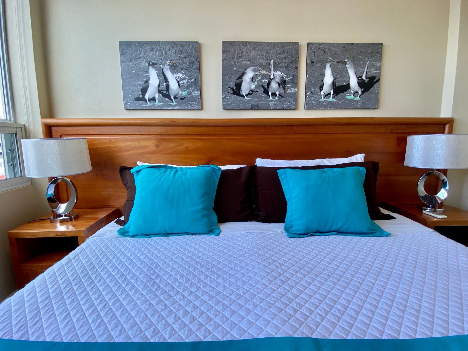 A bed with blue pillows and two lamps in a hotel room