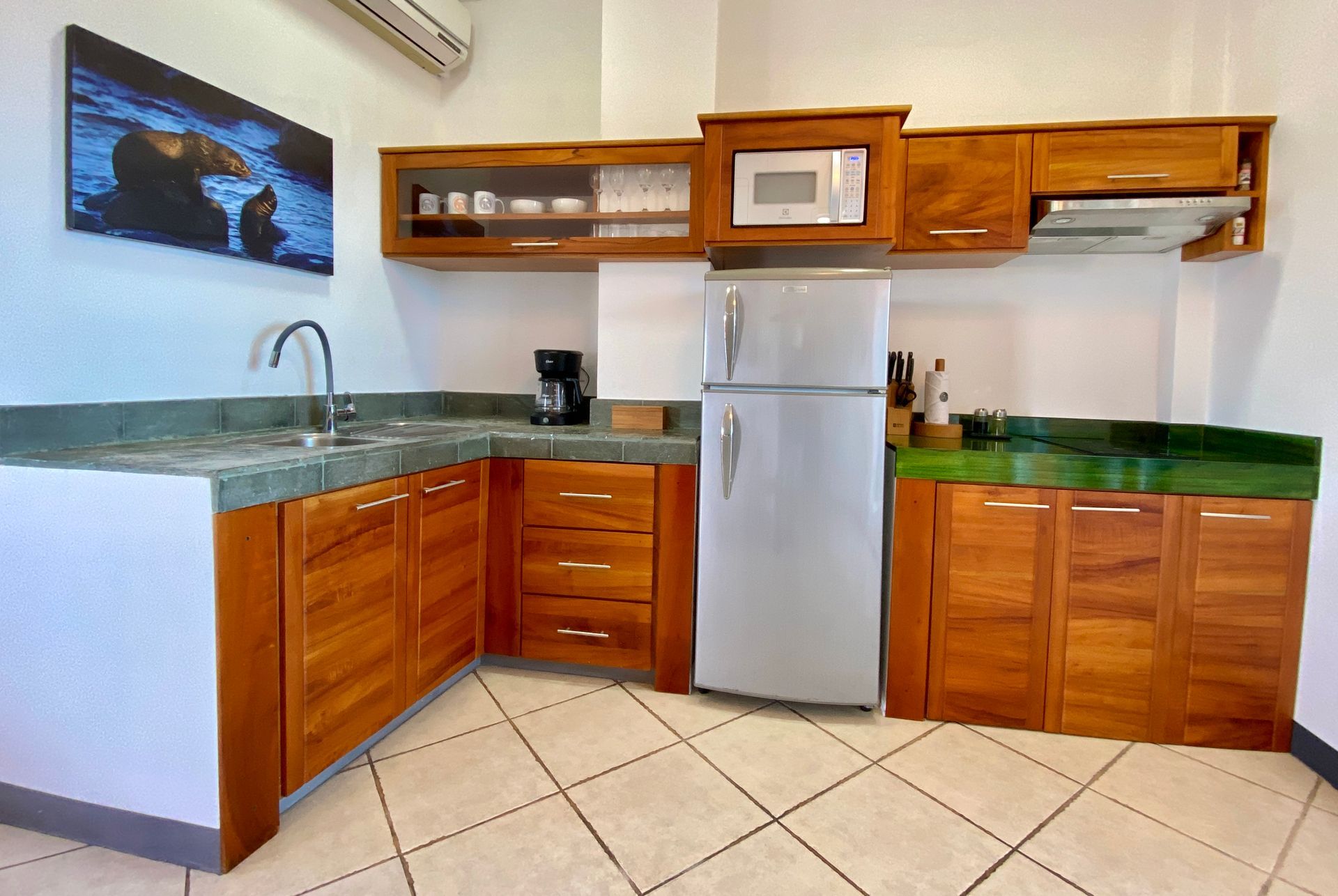 A kitchen with wooden cabinets and a stainless steel refrigerator