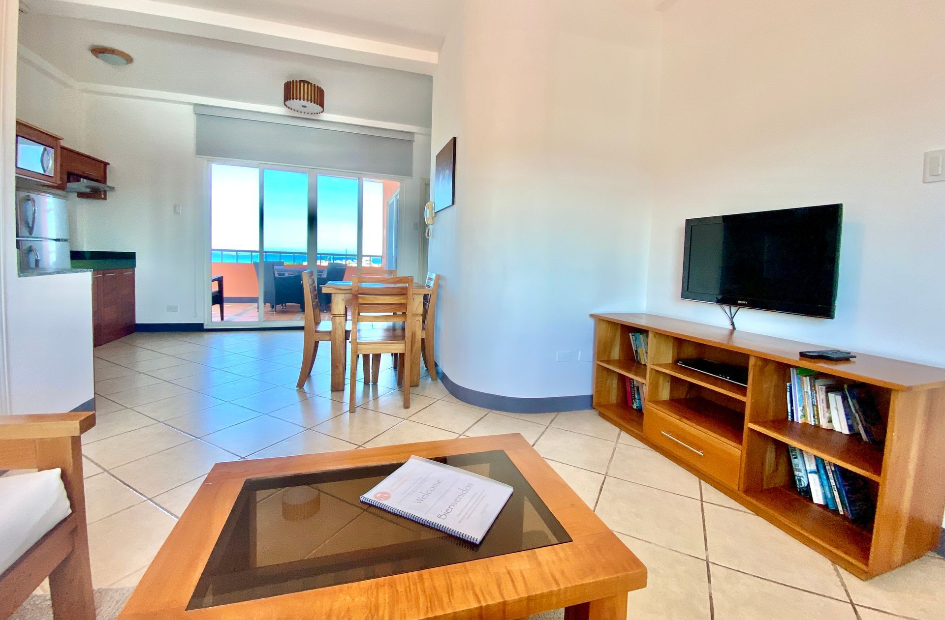 A living room with a table , chairs , and a flat screen tv.