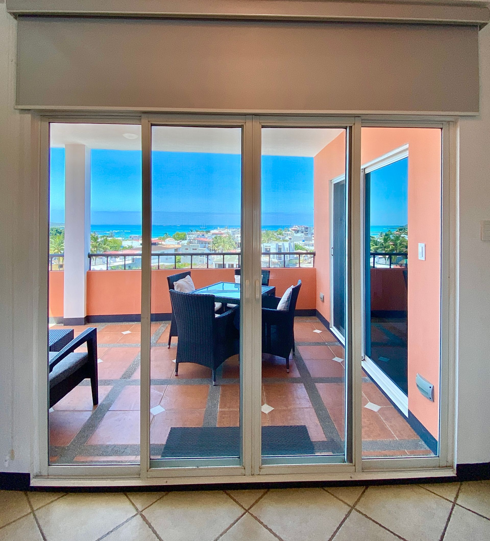 A sliding glass door leads to a balcony overlooking the ocean