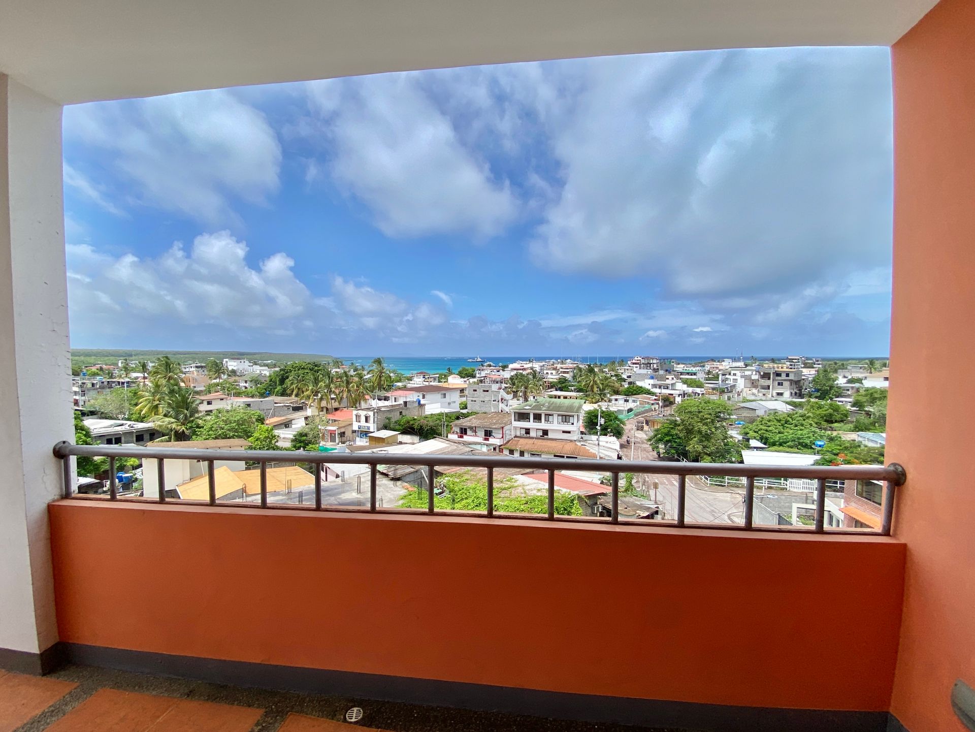A balcony with a view of a city and the ocean