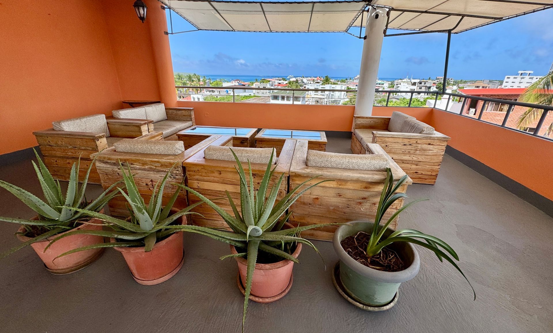 A balcony with potted plants and wooden furniture