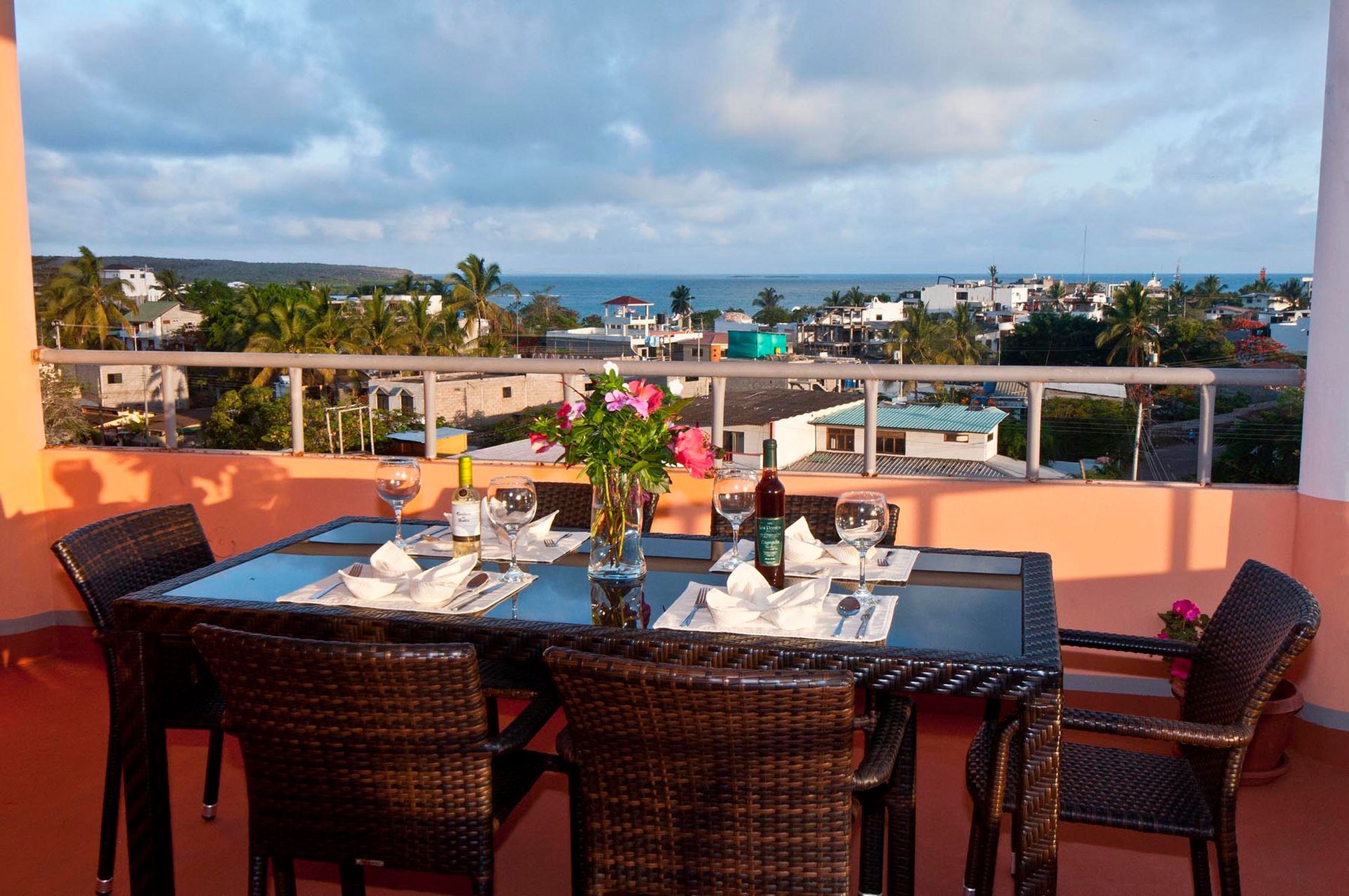 A table and chairs on a balcony overlooking the ocean