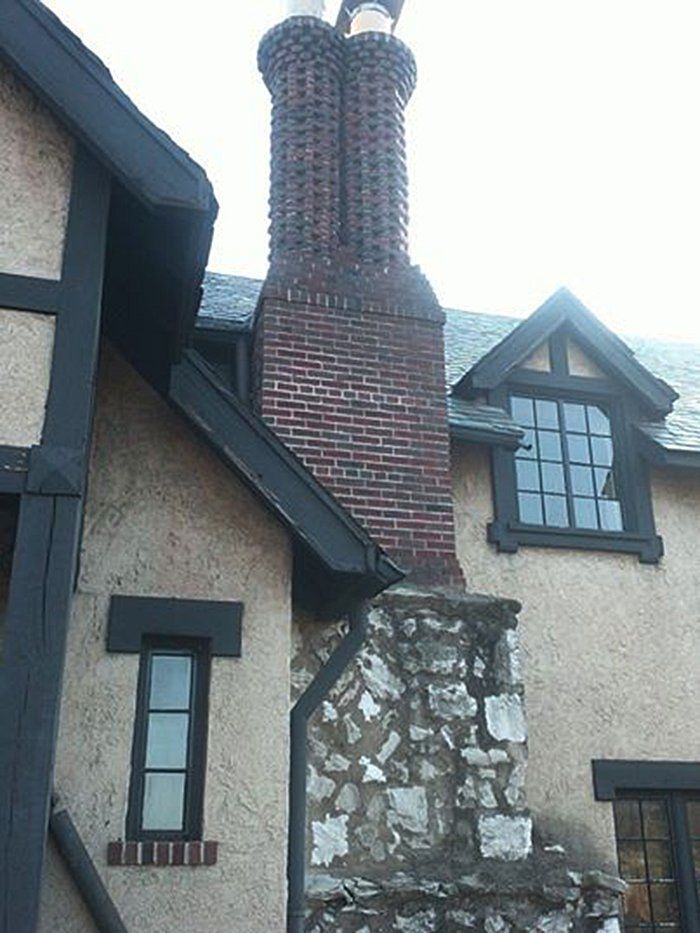 A brick chimney on the side of a building