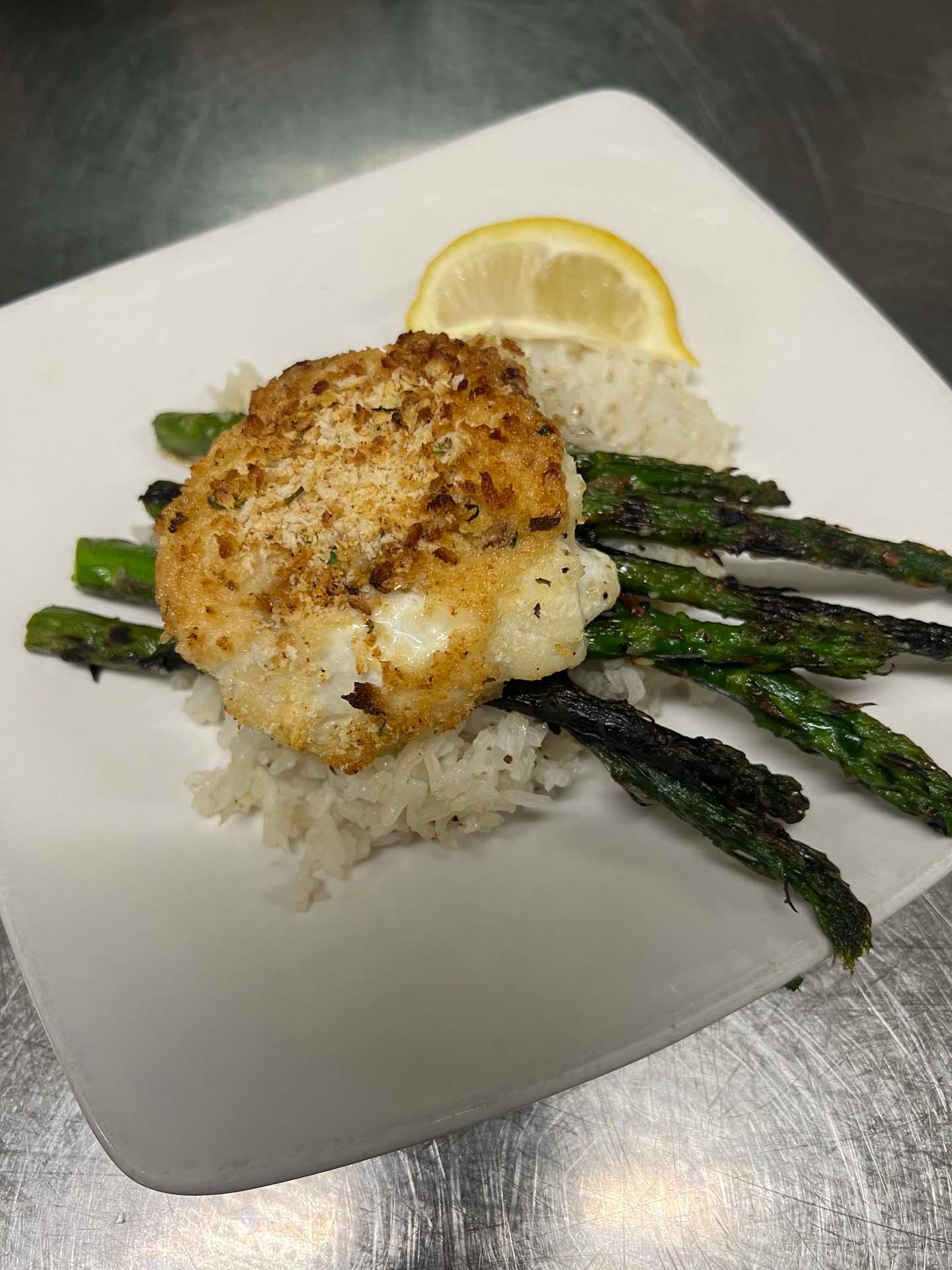 A plate of food with rice and asparagus on a table.