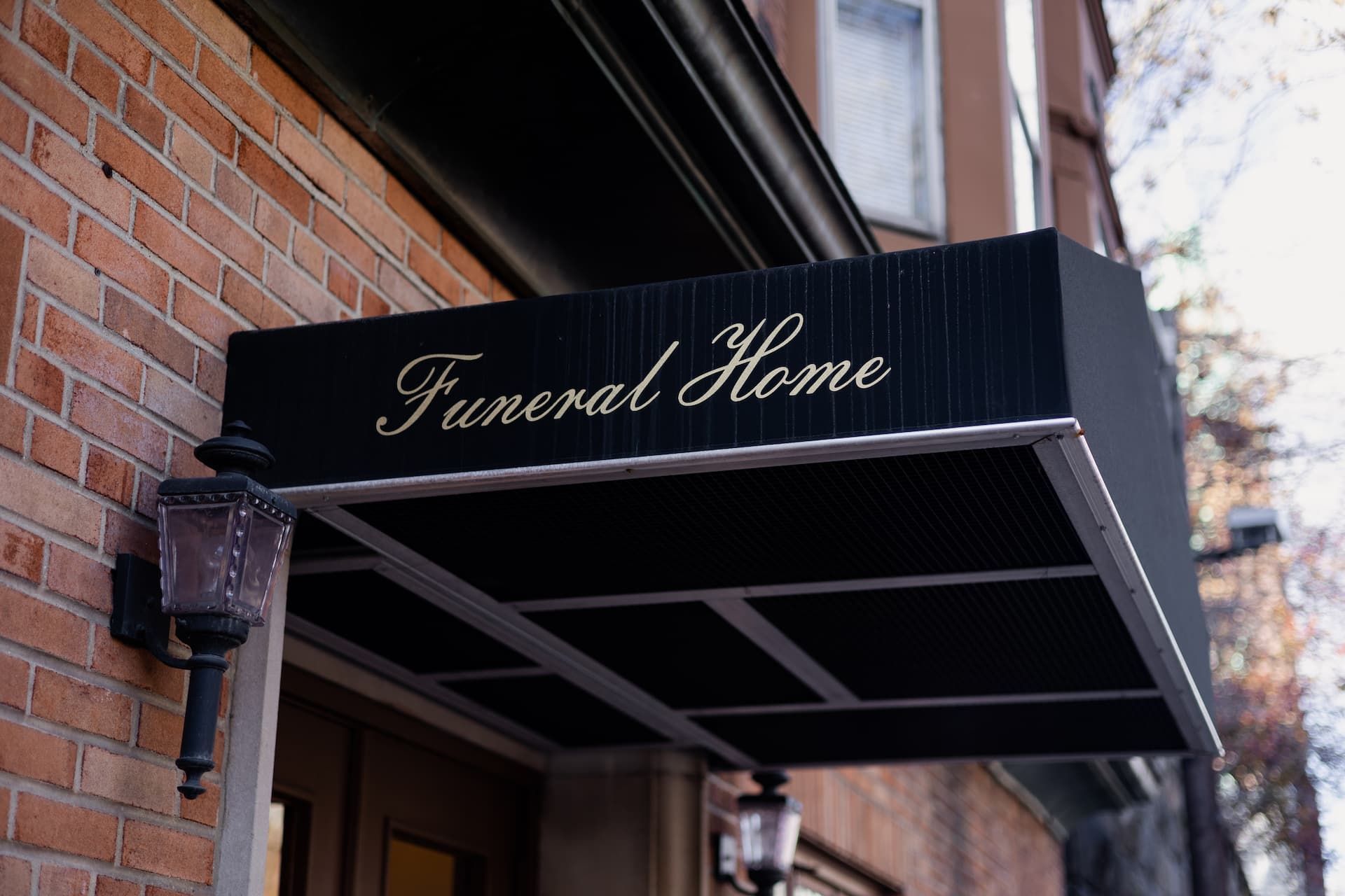 A funeral home with a black awning over the door