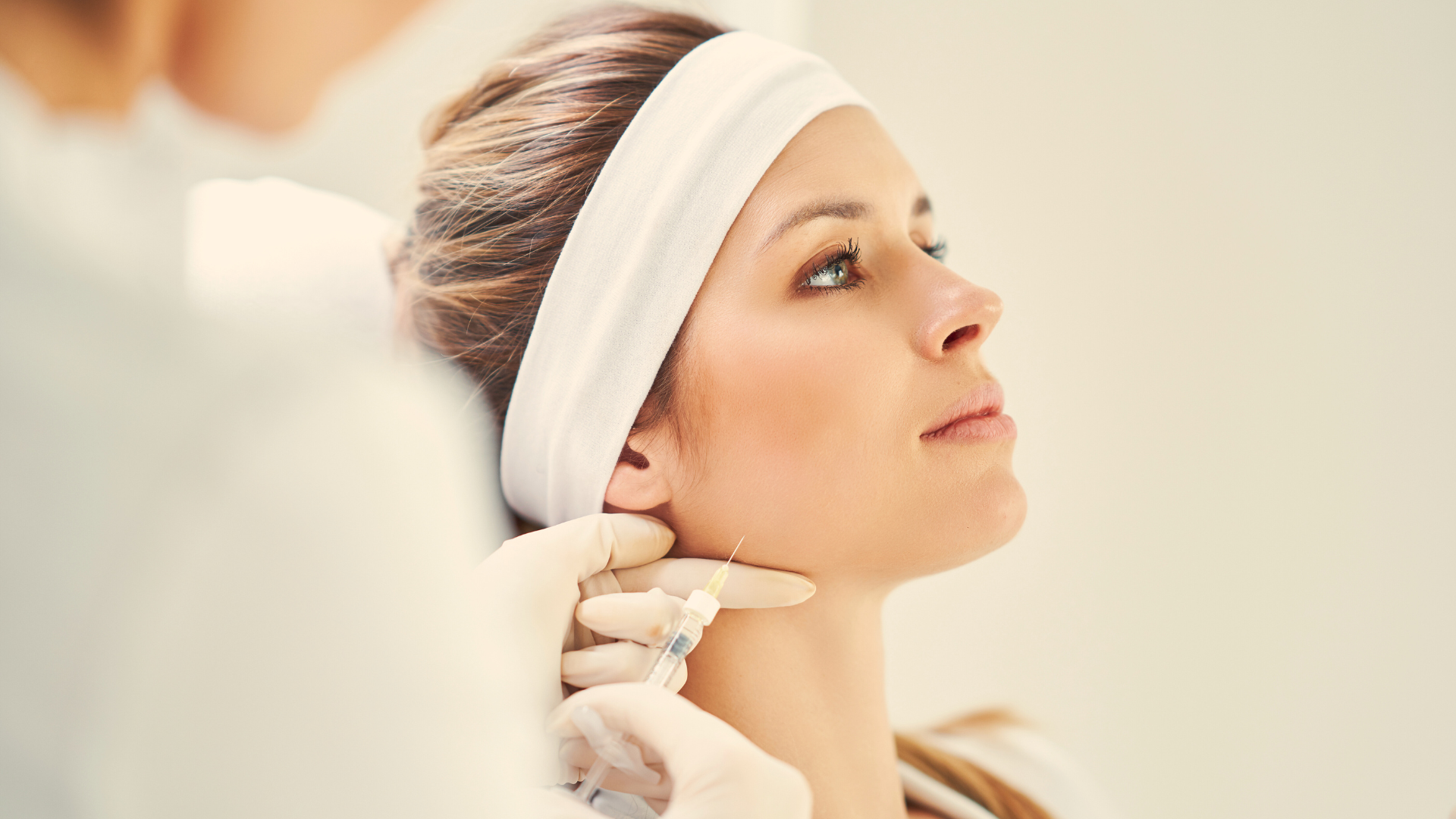 A woman is getting a botox injection in her neck.