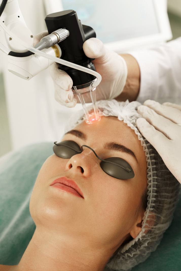 A woman is getting a laser treatment on her face.