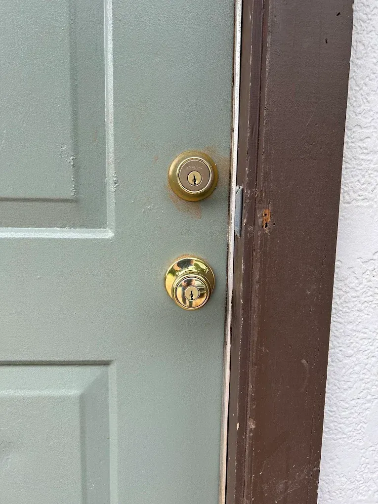 Green door with gold doorknobs.