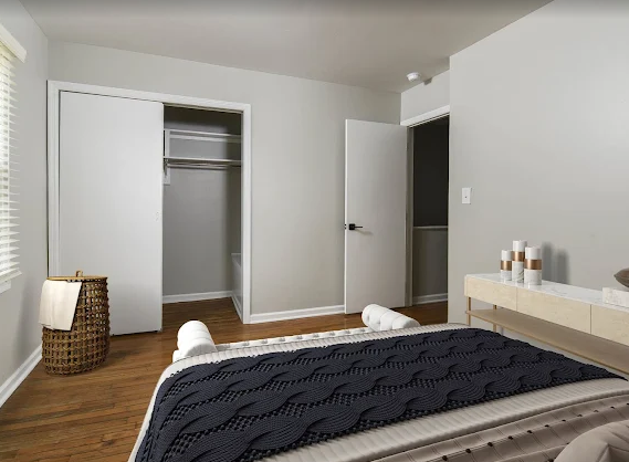 Bedroom with large closet, oak floors, neutral walls 