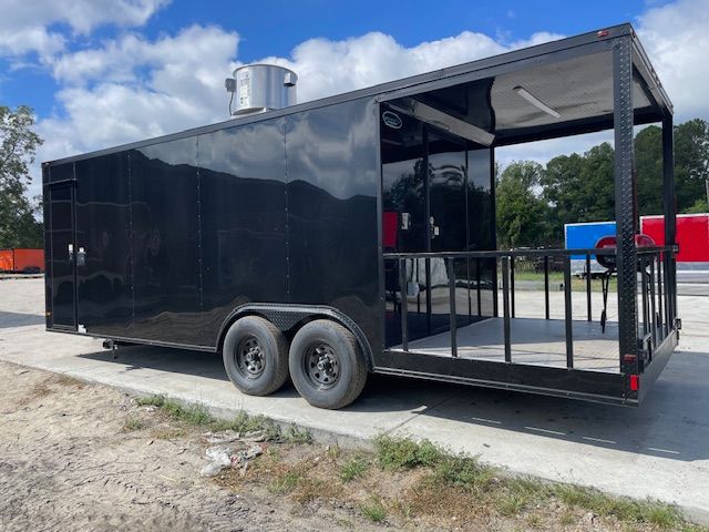 Black food truck trailer with a small patio area.