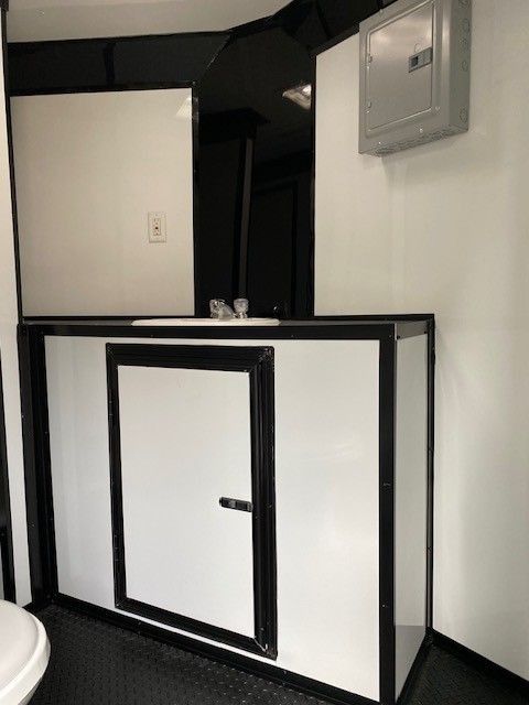 Bathroom with white walls and cabinet, black trim, and a sink.