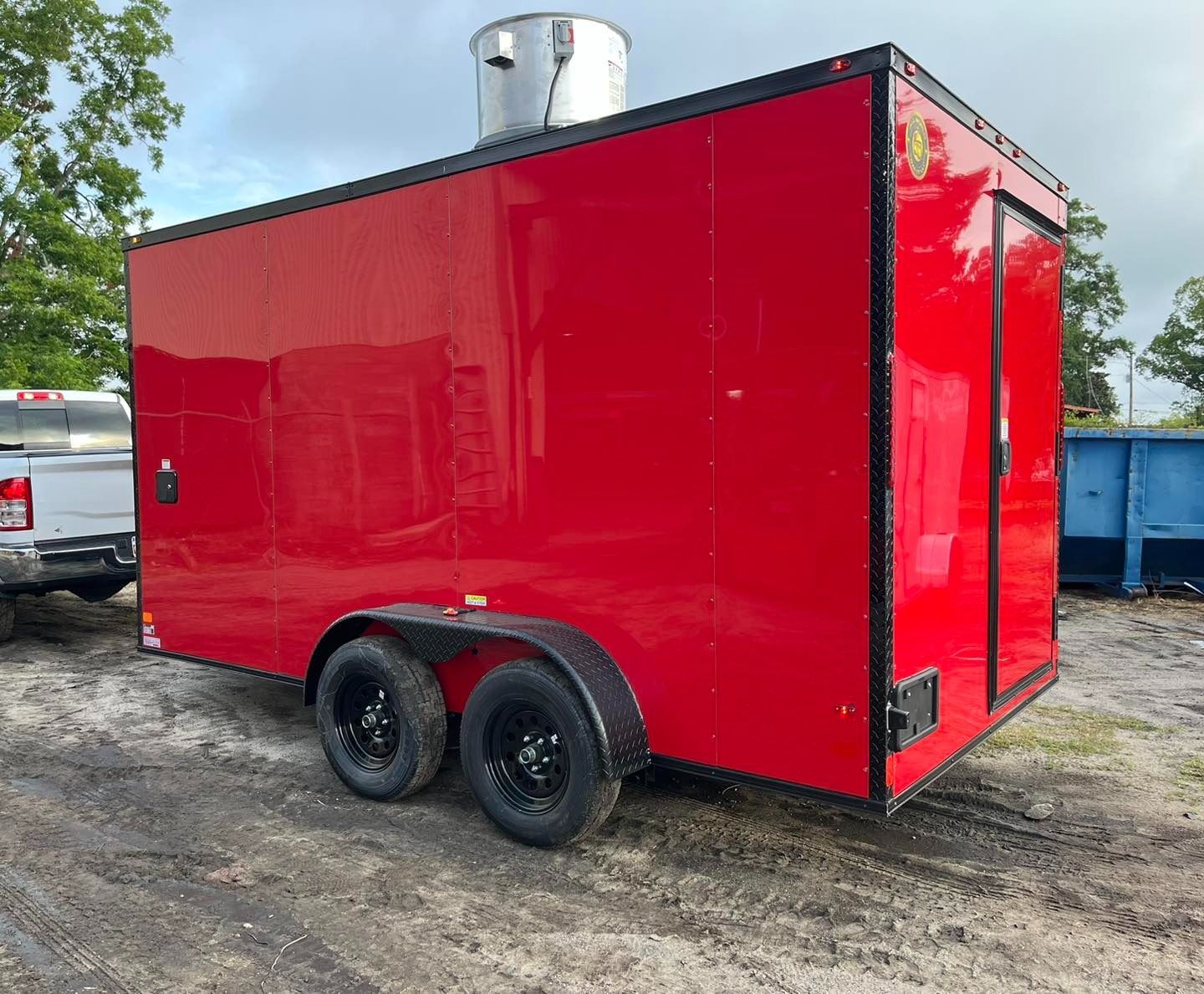 Red food trailer with black trim and tires. Outdoor setting.