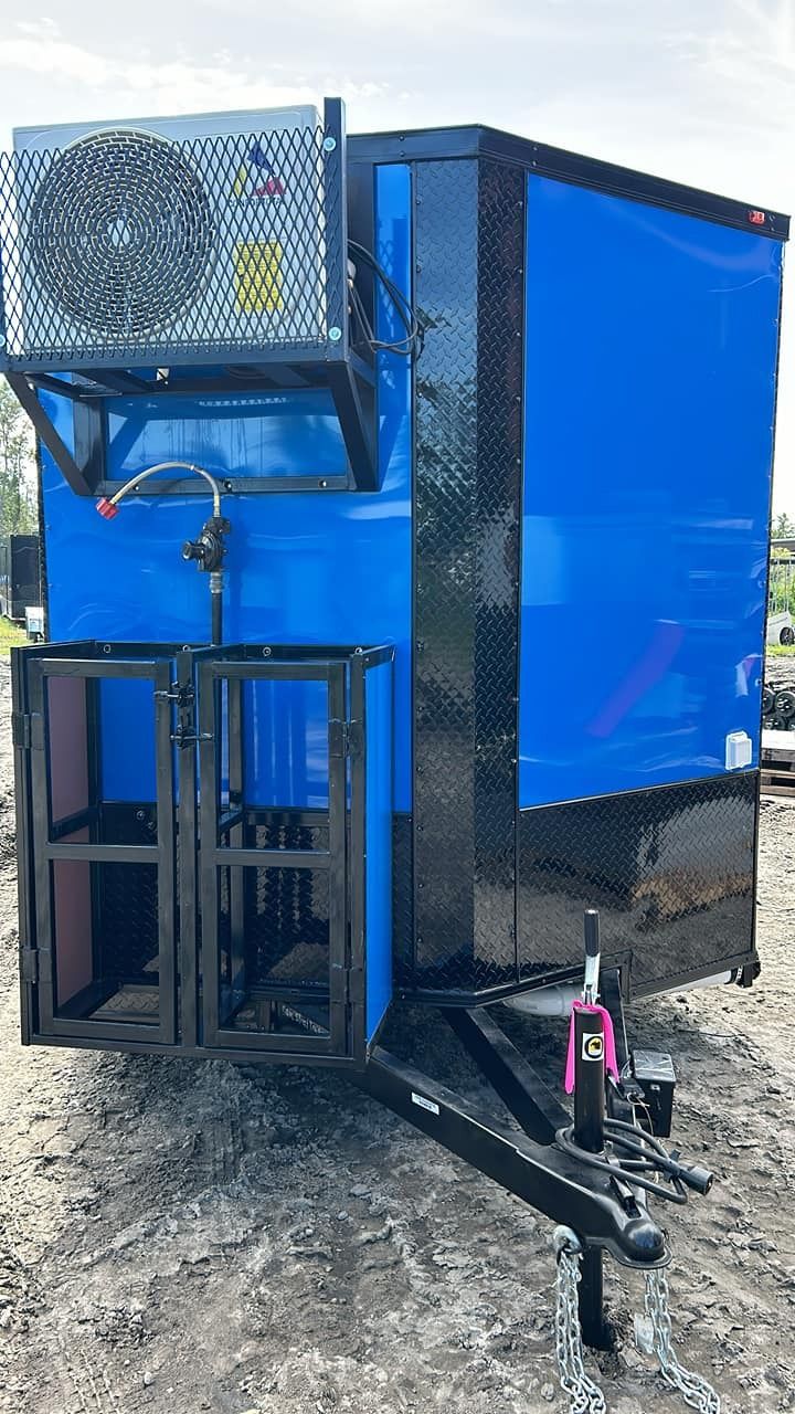 Blue and black trailer with an air conditioner unit and a caged door.