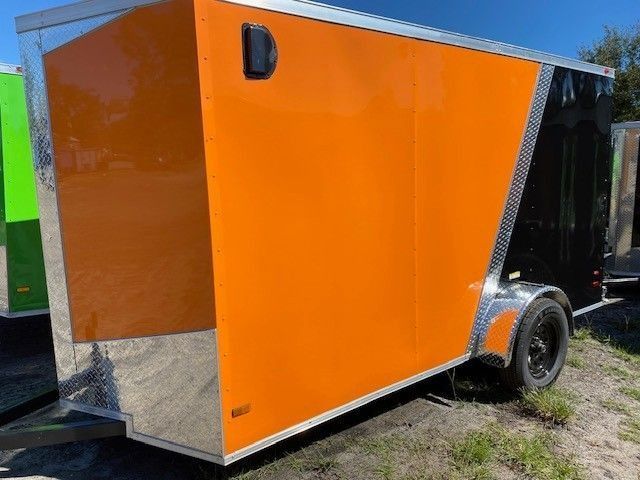 Orange and black enclosed cargo trailer on a sunny day.