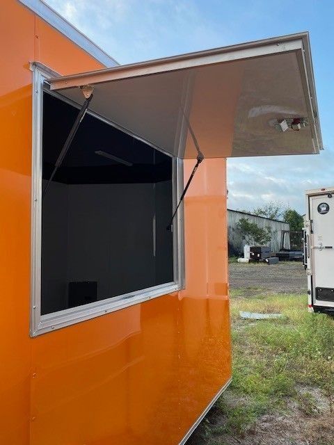 Orange food trailer with an open service window.
