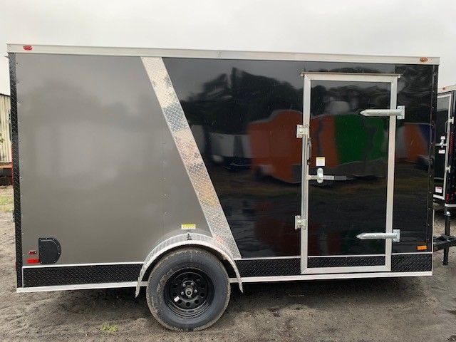 Enclosed cargo trailer, gray and black, with side door, black wheel, and diamond plate trim.