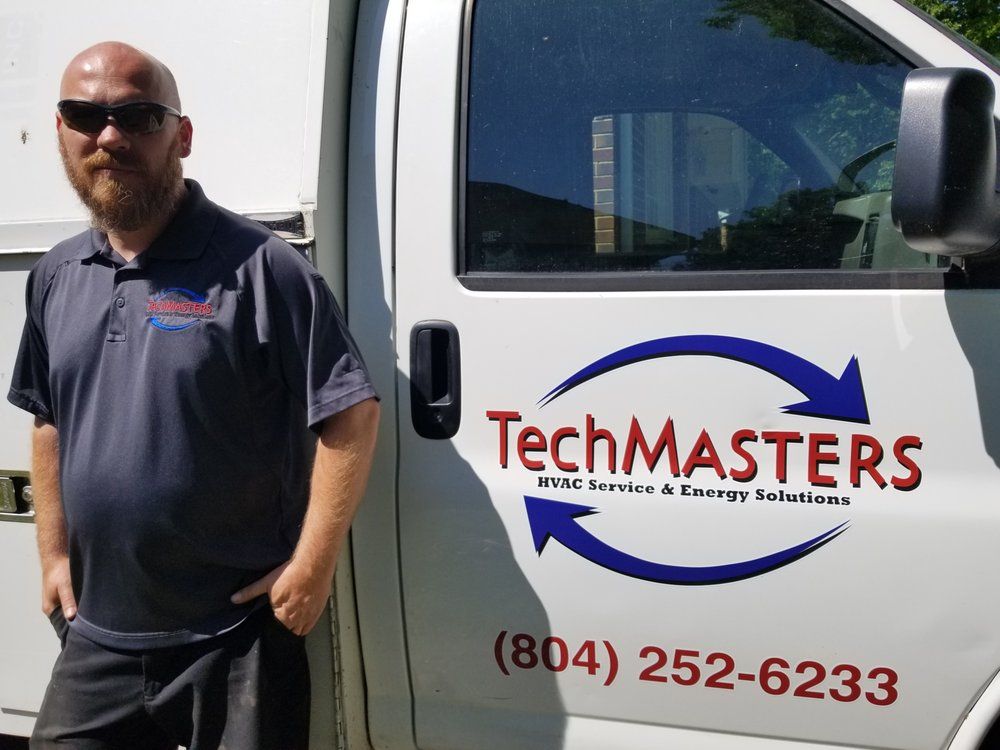 A man is standing in front of a techmasters van