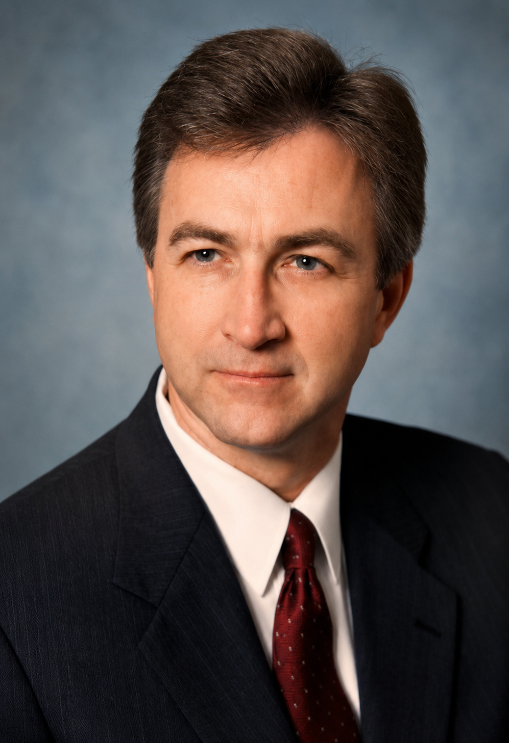 Michael Marlow headshot. A man in a suit and maroon tie.