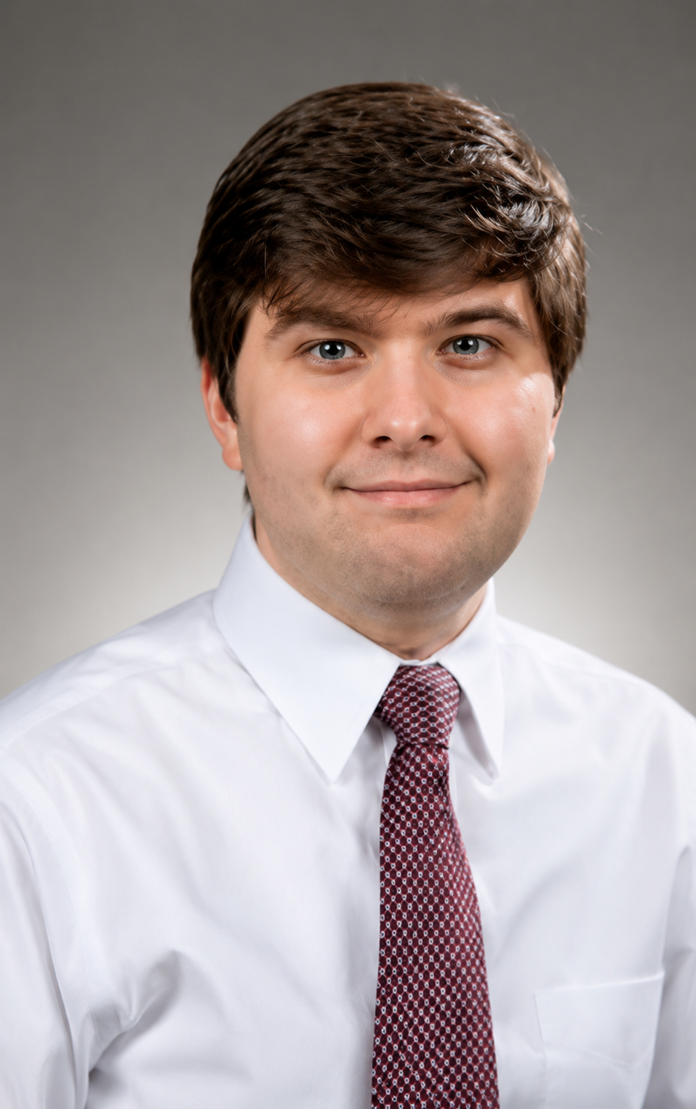 William Marlow headshot. A man in a white shirt and maroon tie.