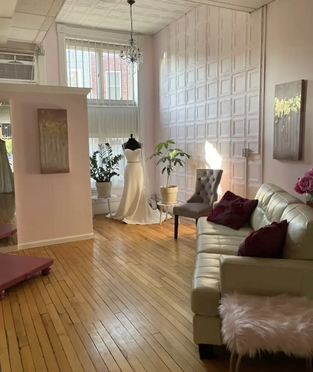 A living room with a couch , chair , and mannequin.
