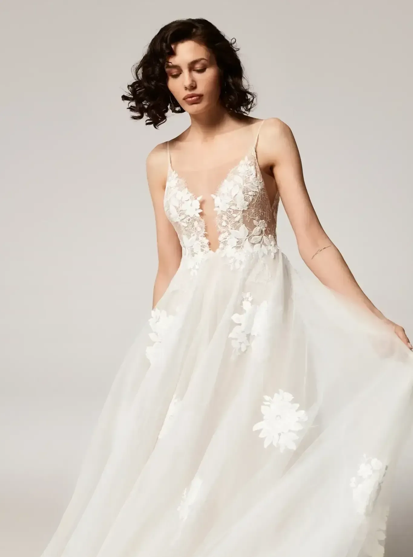 A woman is wearing a white wedding dress with a plunging neckline.