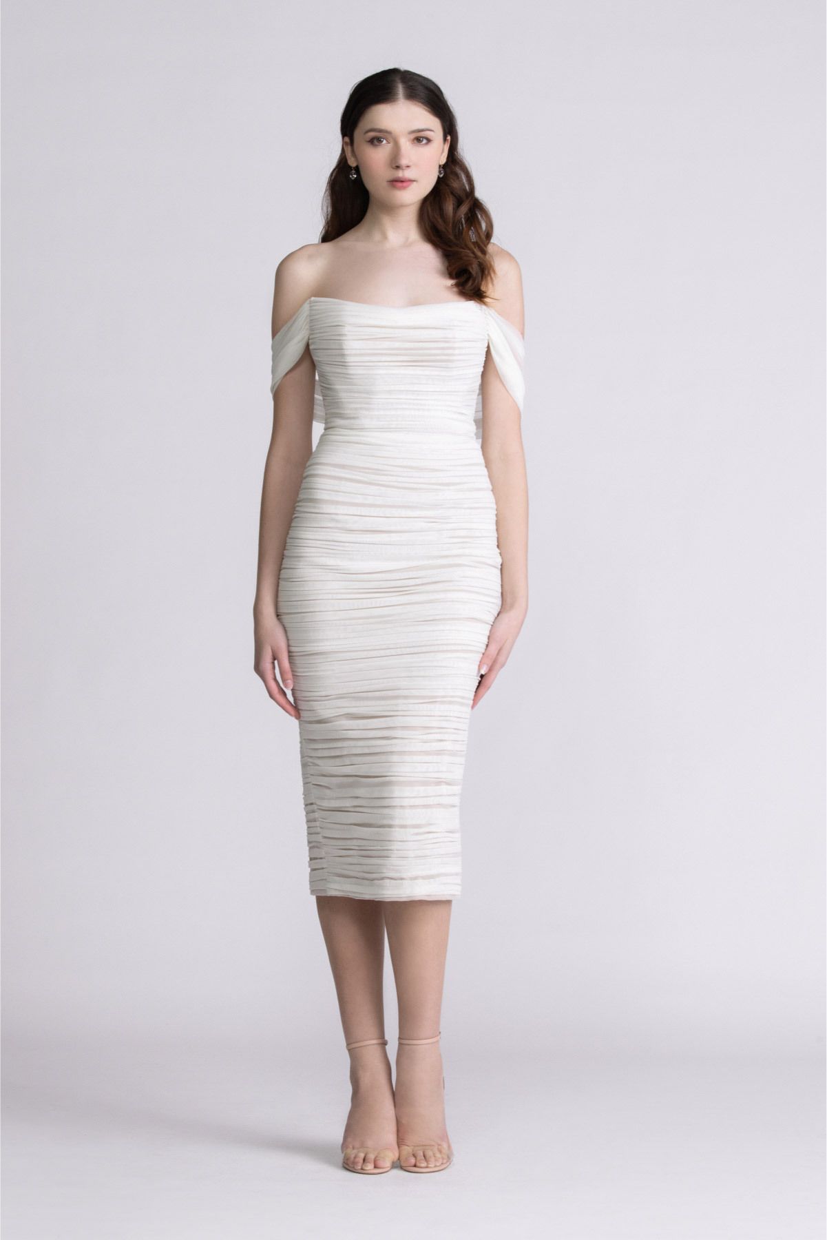 A woman is wearing a white off the shoulder dress.