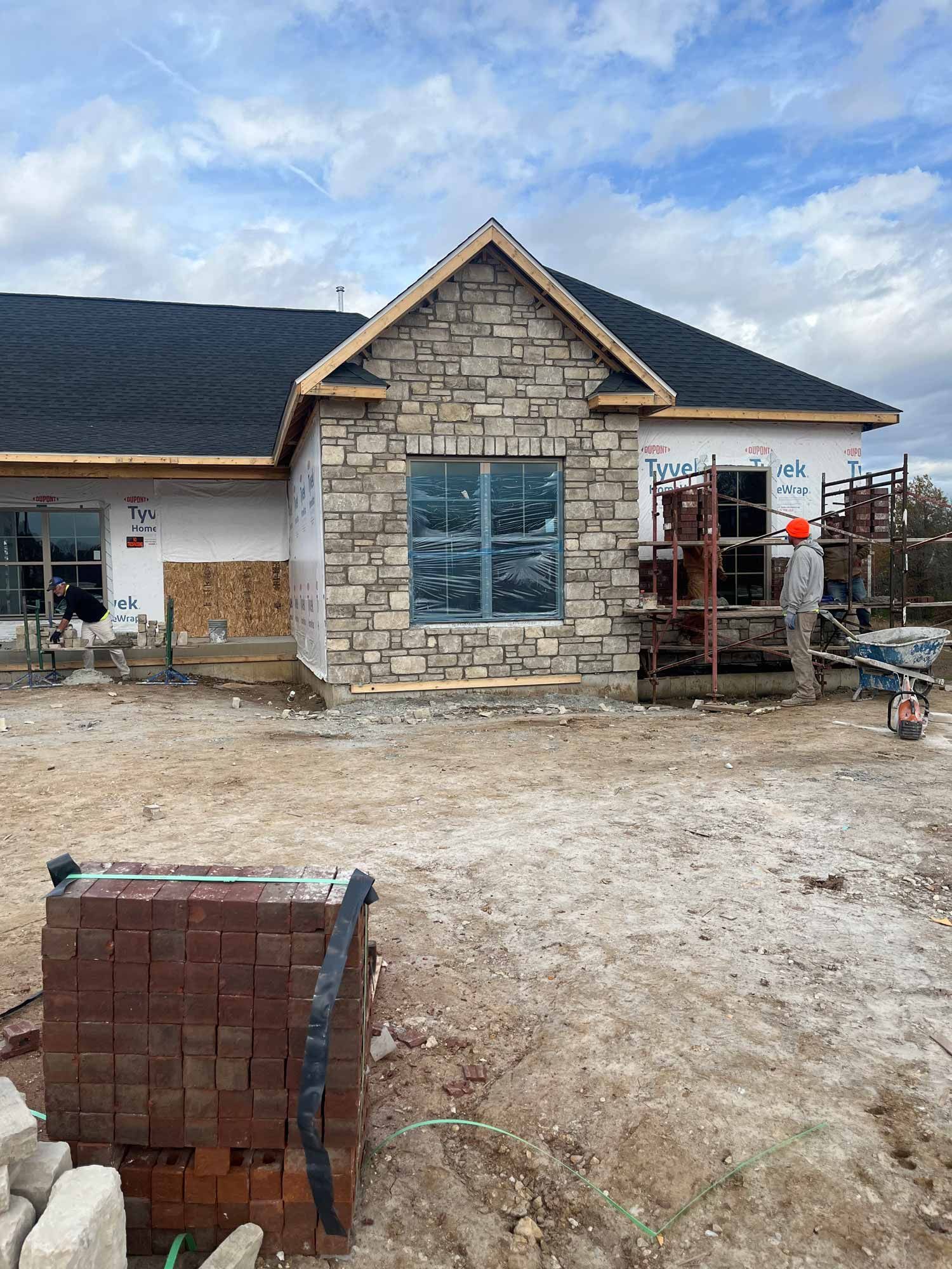 A house is being built with bricks and a black roof.