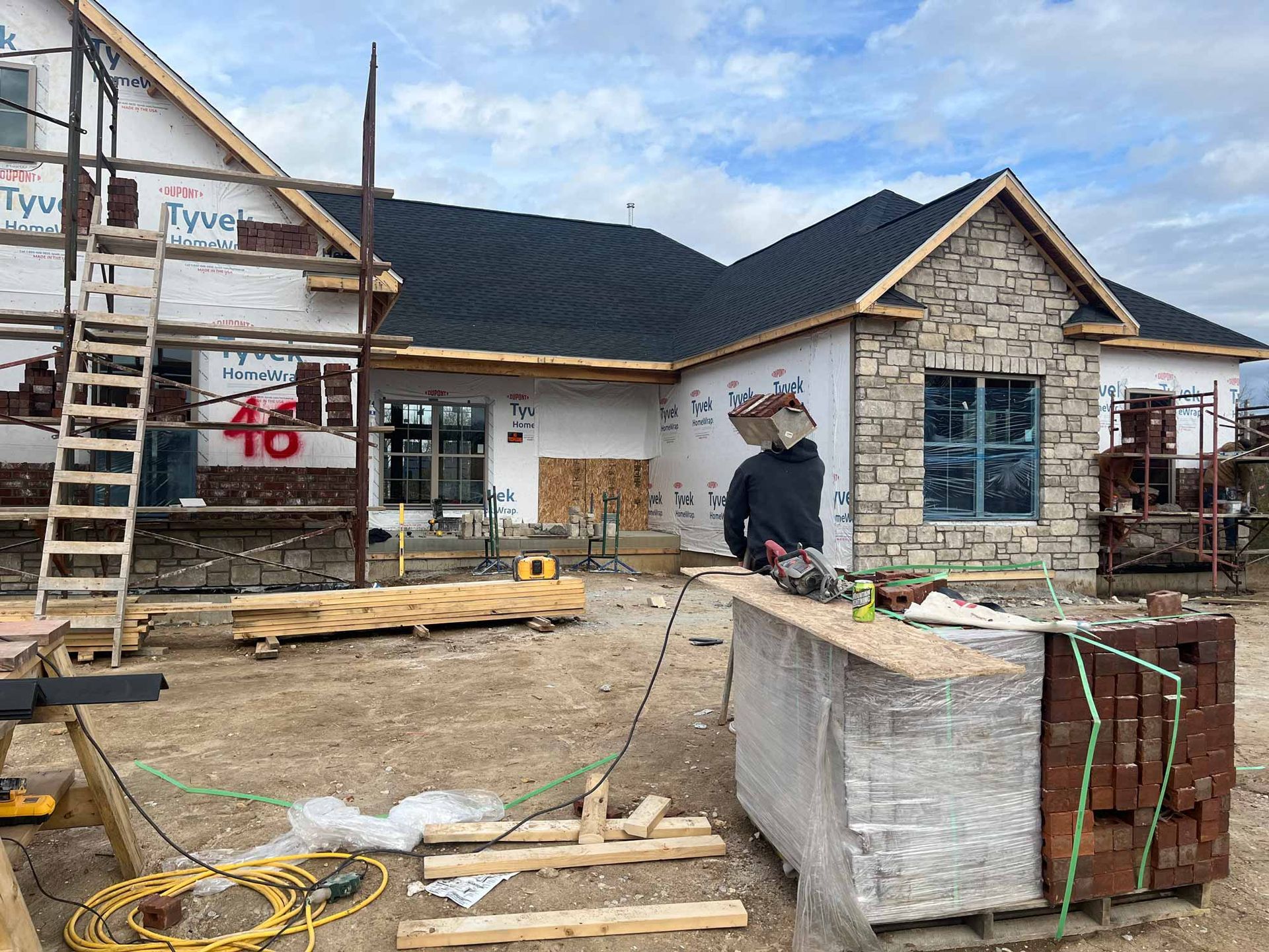 A man is standing in front of a house that is being built.