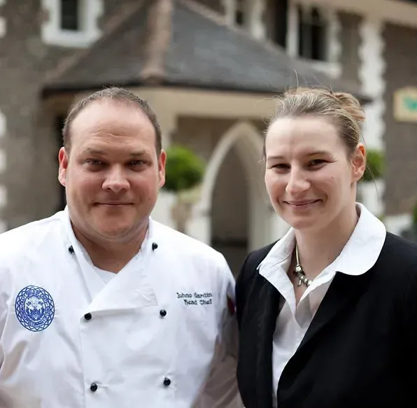 A man and a woman are posing for a picture in front of a building