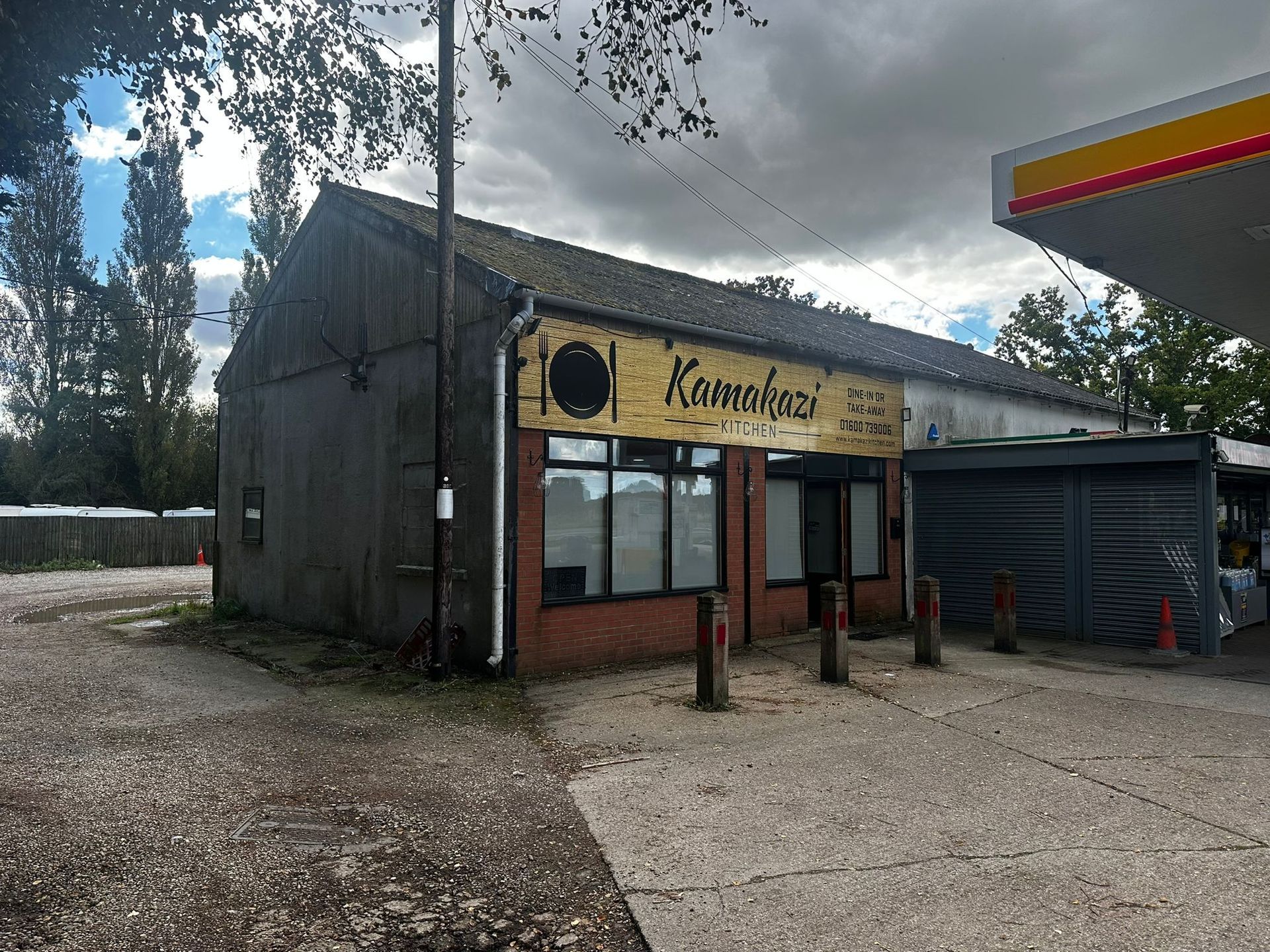 A brick building with a yellow sign that says ' kamakazi ' on it