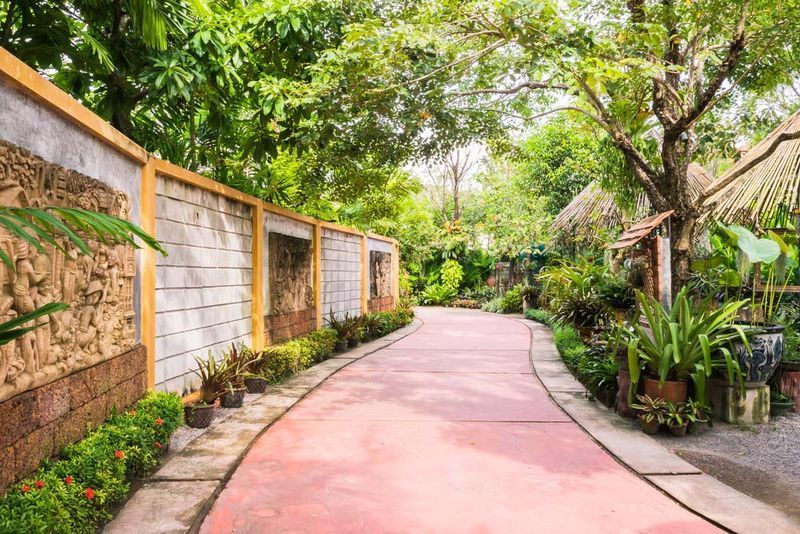 A Red Walkway Winds Through a Lush Garden — Easy Mix Concrete In Erina, NSW