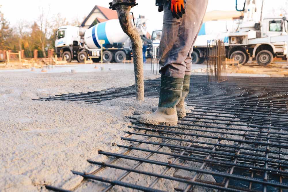 Worker Pours Concrete Onto Rebar Foundation — Easy Mix Concrete In Erina, NSW