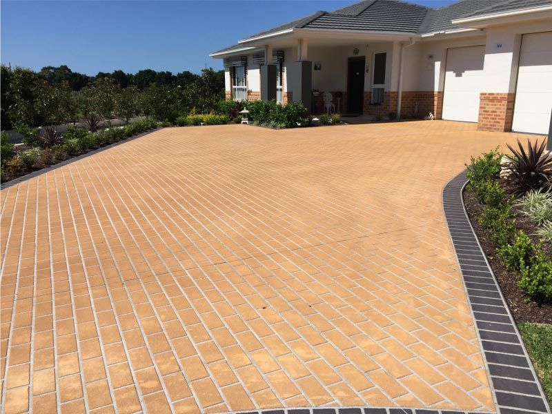 Tan Brick Driveway Leading to a White House — Easy Mix Concrete In Berkeley Vale, NSW