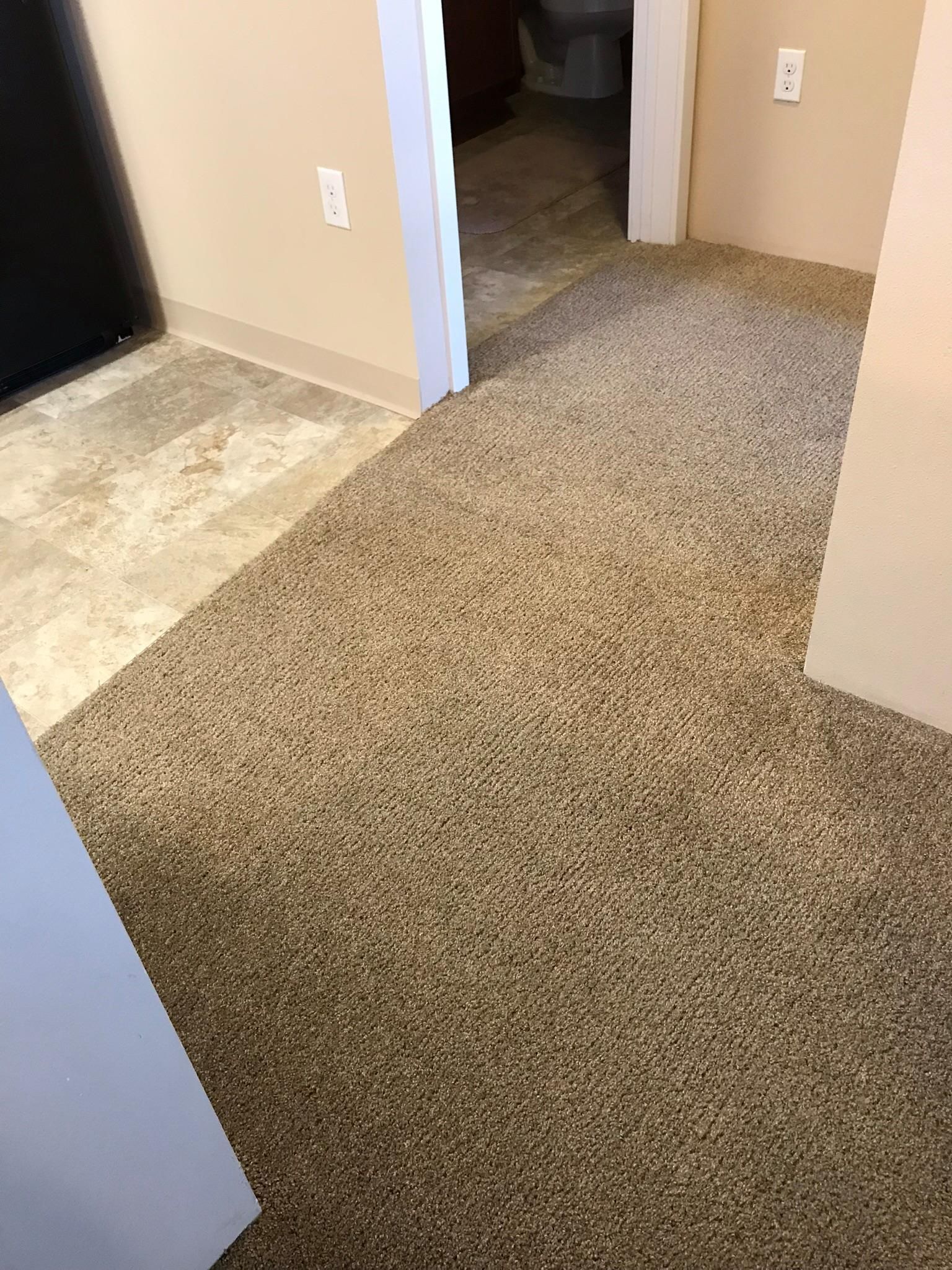 A room with a carpeted floor and a tiled floor.