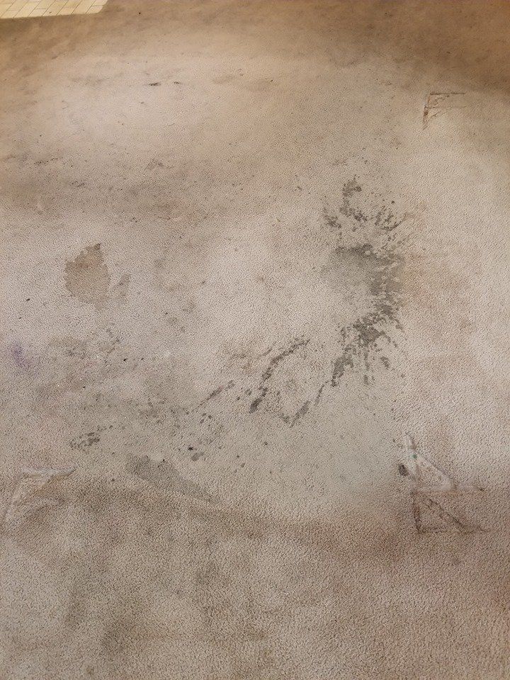 A close up of a concrete floor with a lot of stains on it.