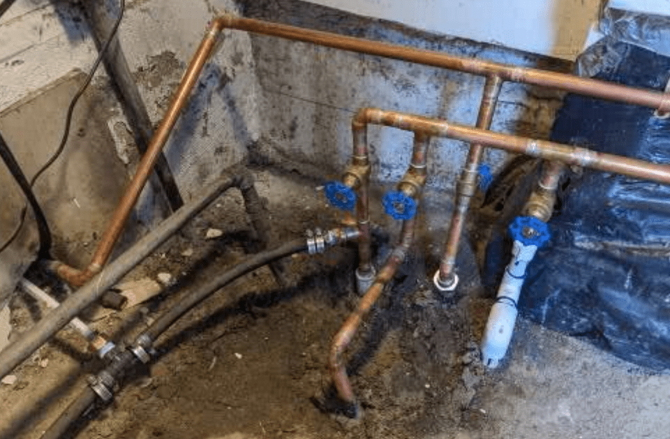 A bunch of copper pipes are connected to each other in a room.