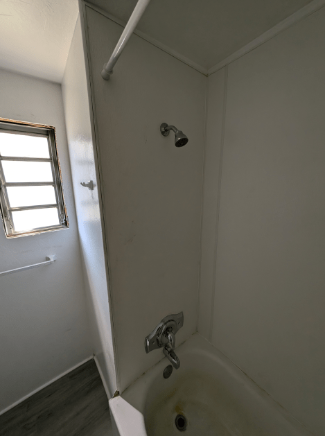 A bathroom with a bathtub and a shower.