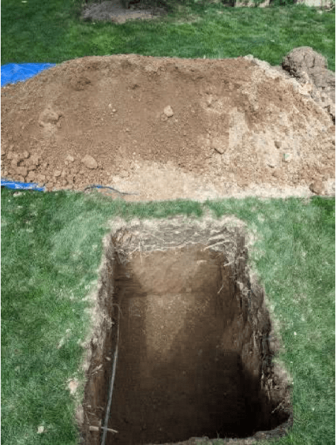 A pile of dirt next to a hole in the ground.