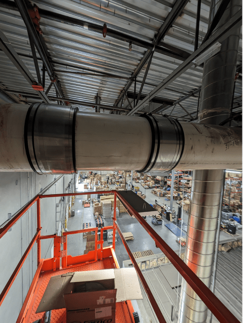 A large pipe is hanging from the ceiling of a building