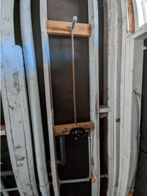 A bunch of surfboards are stacked on top of each other in a room.